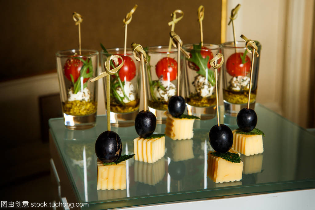 乳酪小吃与不同的蔬菜和草药搭配在棕色餐桌上的餐饮服务宴会
